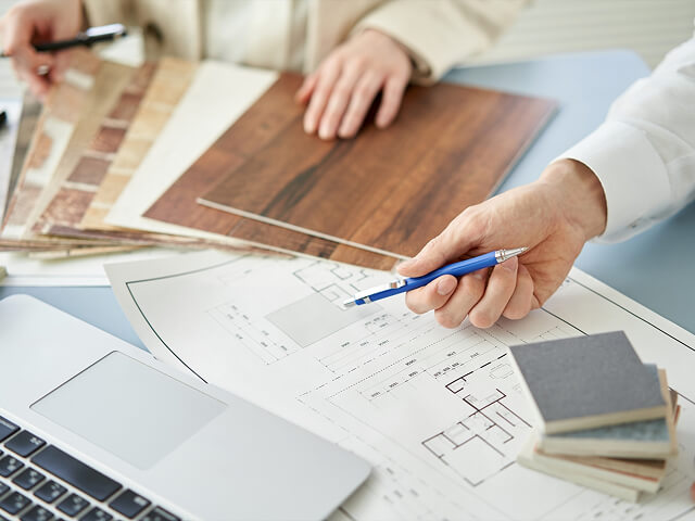 ペンを持っている担当者がパソコンの前で話している様子